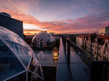 a rooftop with clear dome structures and a city in the background