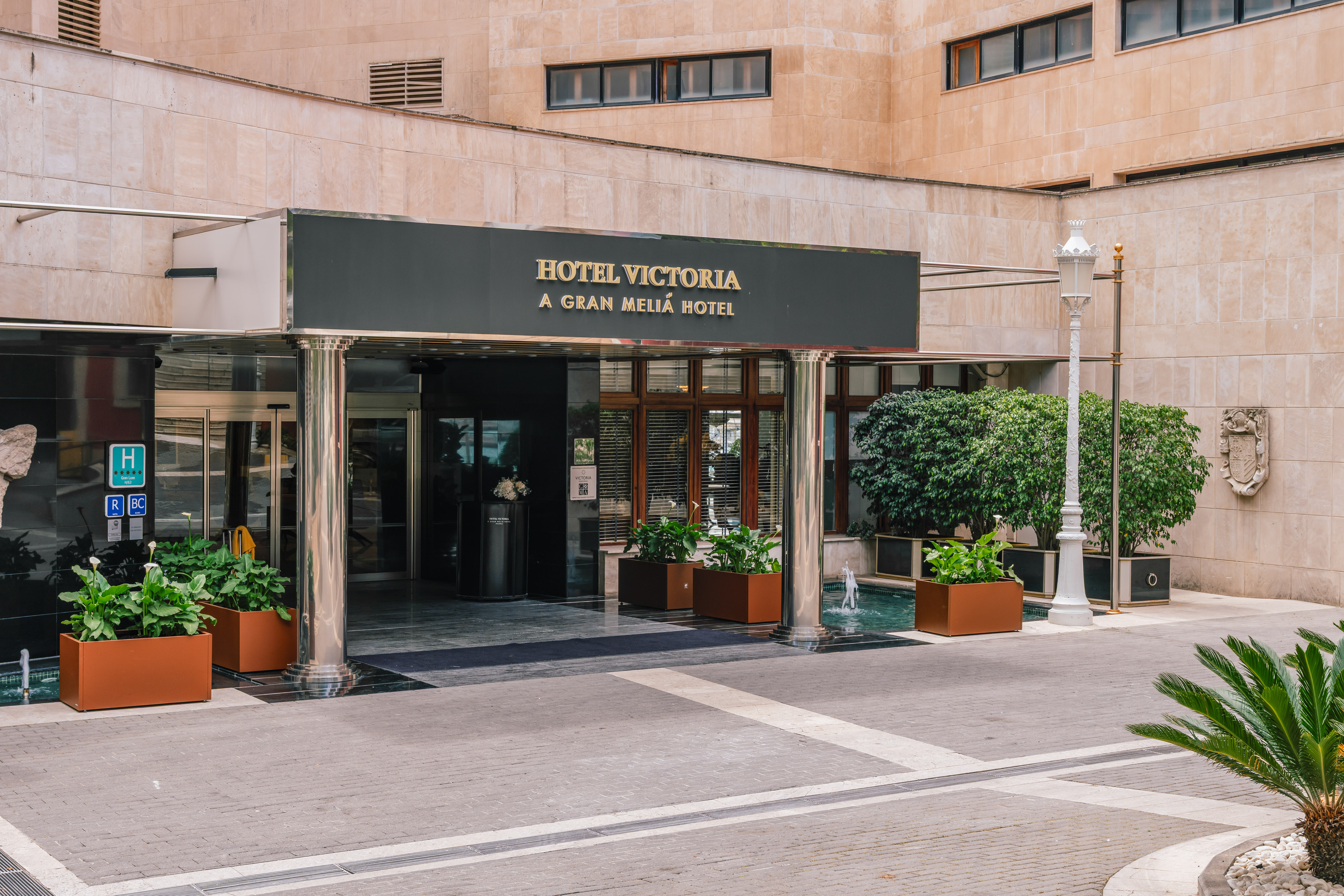 Hotel Victoria Gran Meliá luxury hotel entrance, modern facade, plants, fountain.