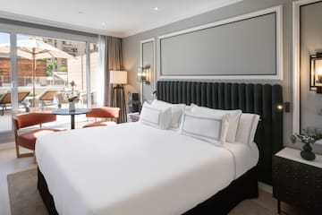 a bed with white sheets and a black headboard in a room