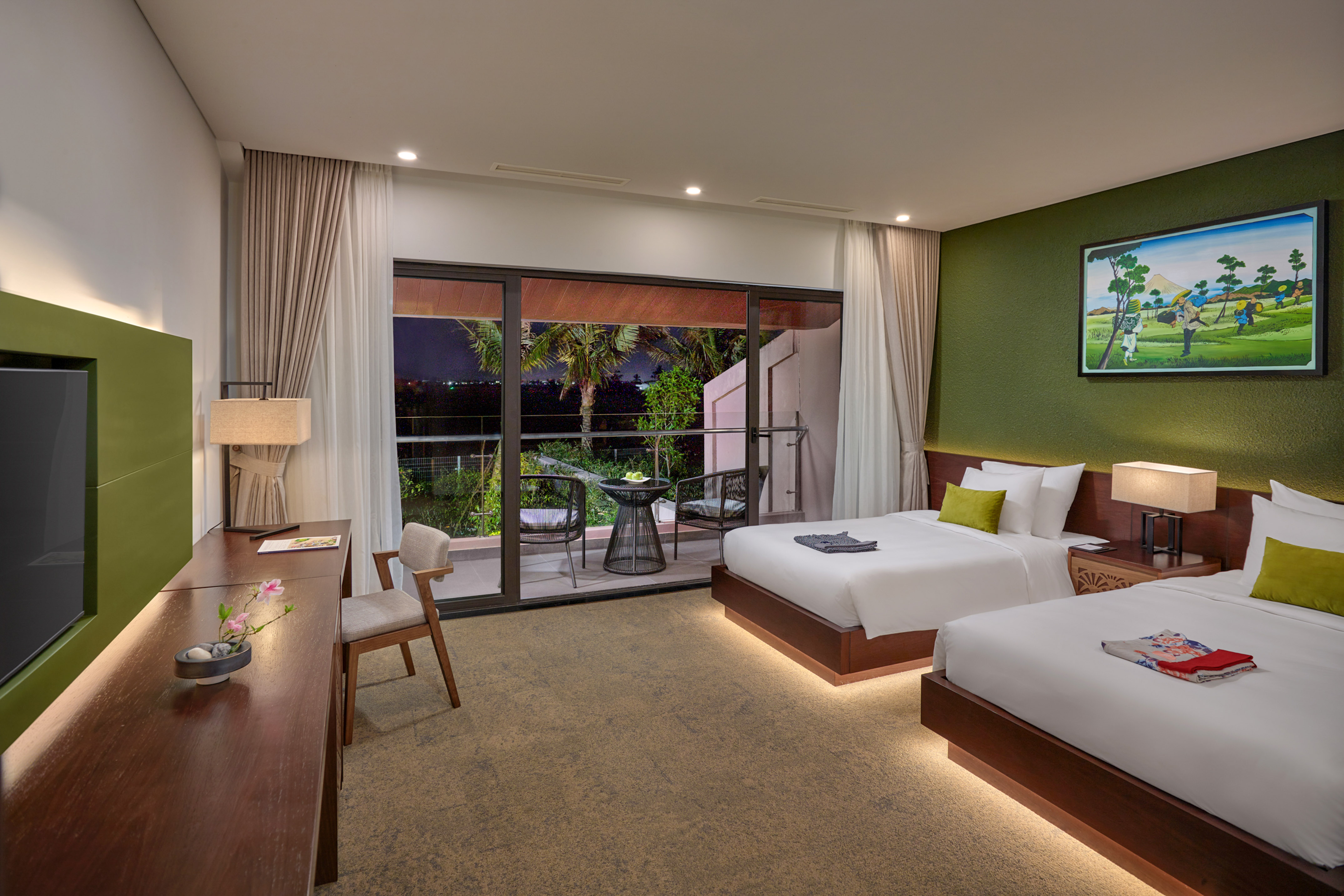 Luxury resort room with two beds and private balcony at night.