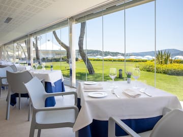 a table set up with white and blue tables and chairs outside