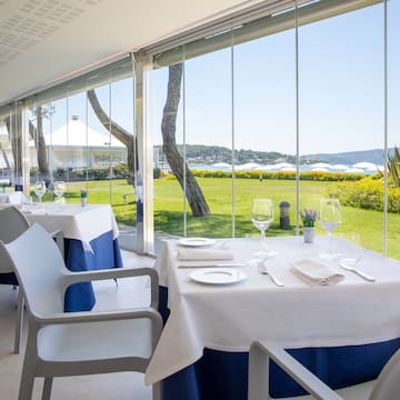 a table set up with white and blue tables and chairs outside