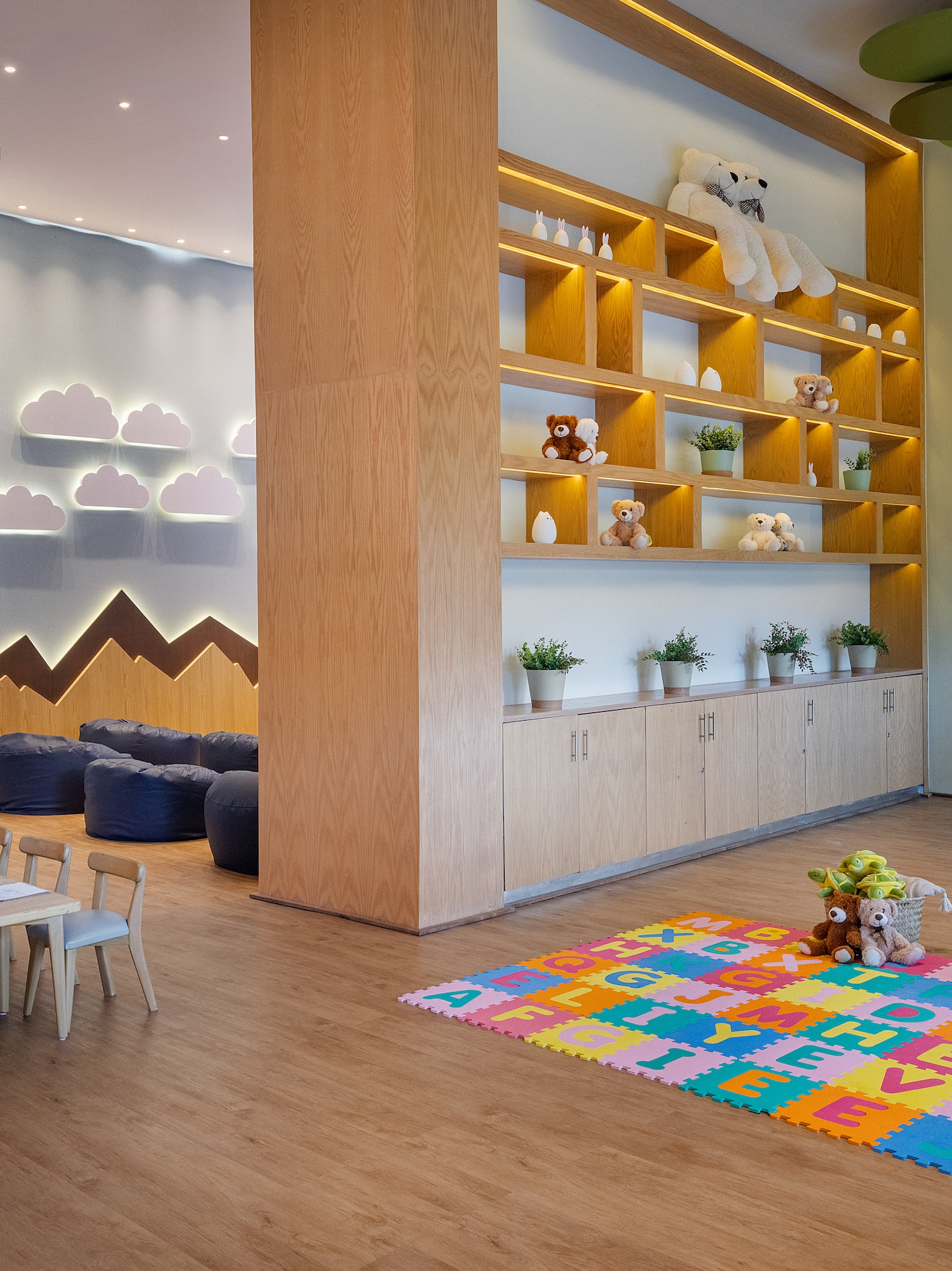 Modern children's playroom with alphabet mat, activity table, and tree decor.