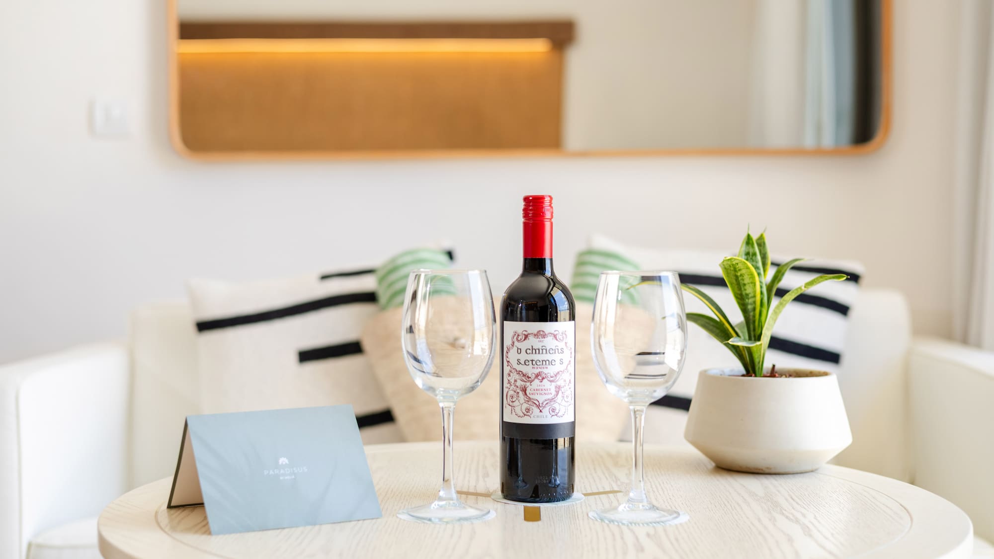 a wine bottle and wine glasses on a table