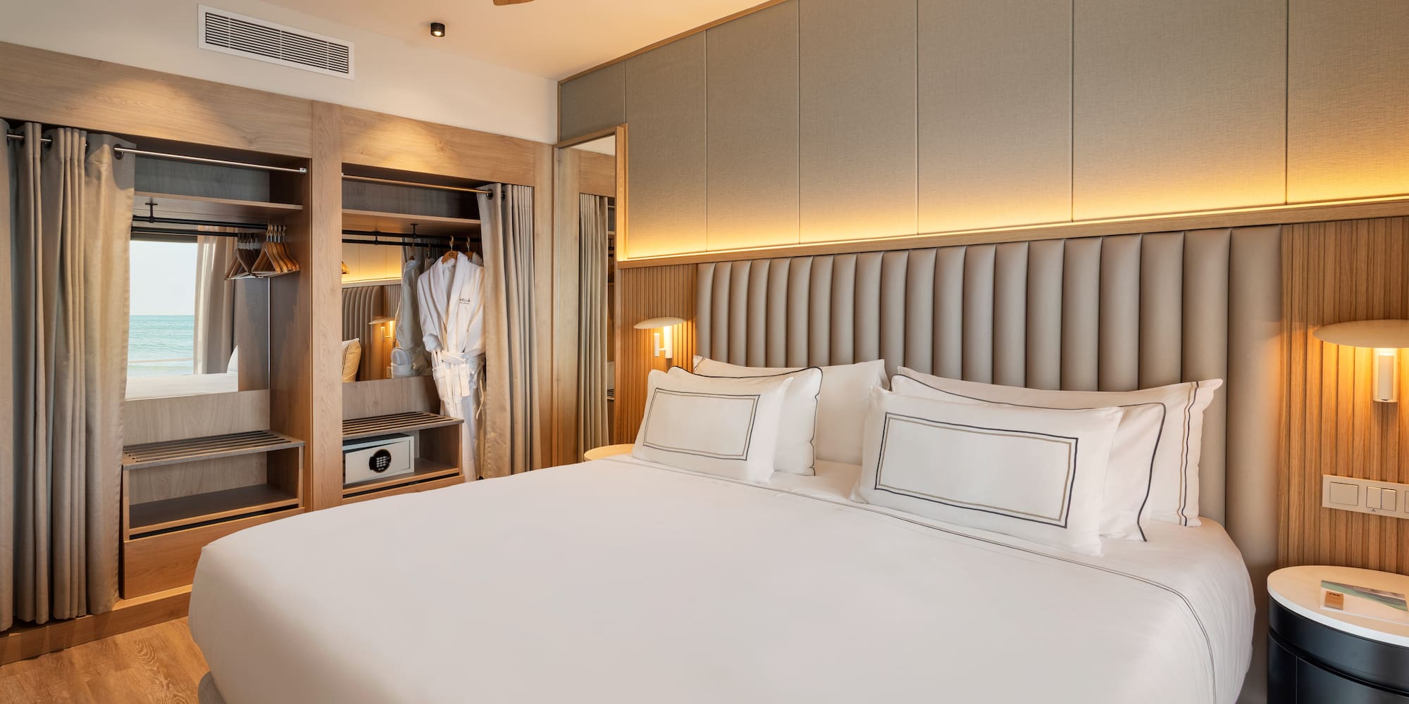 a bed with white sheets and a closet in the background