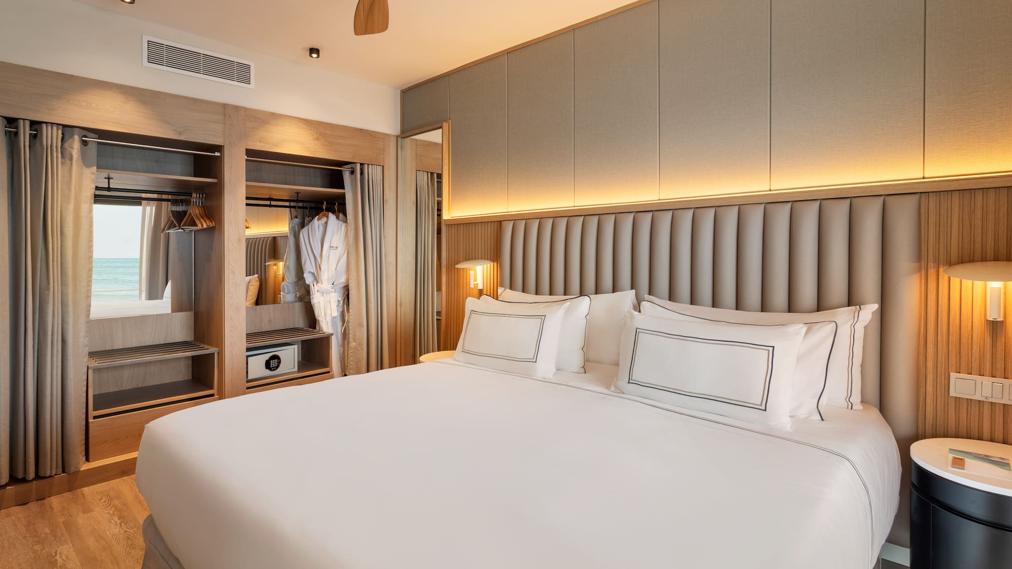 a bed with white sheets and a closet in the background