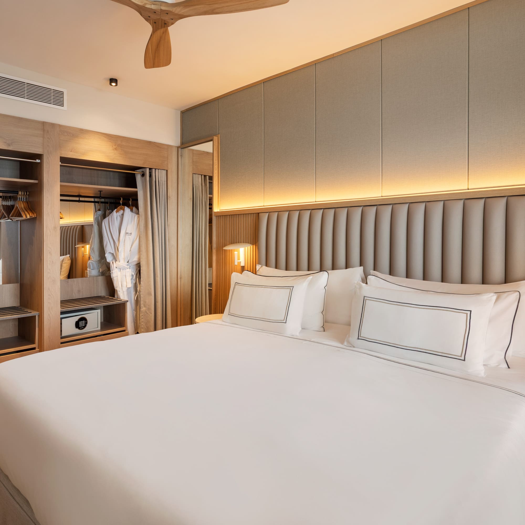 a bed with white sheets and a closet in the background