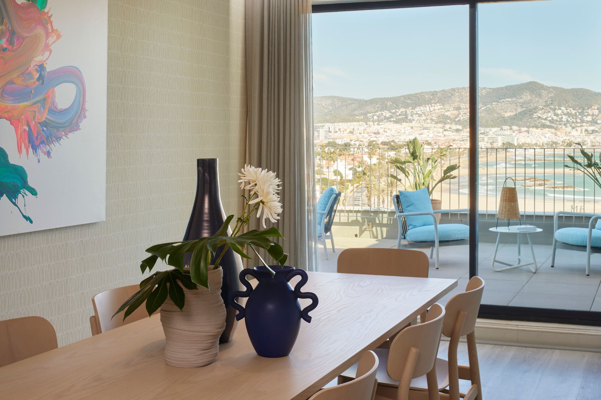 a table with chairs and vases on it