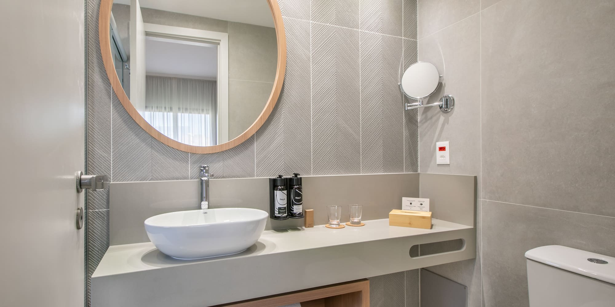 a bathroom with a round mirror and a sink