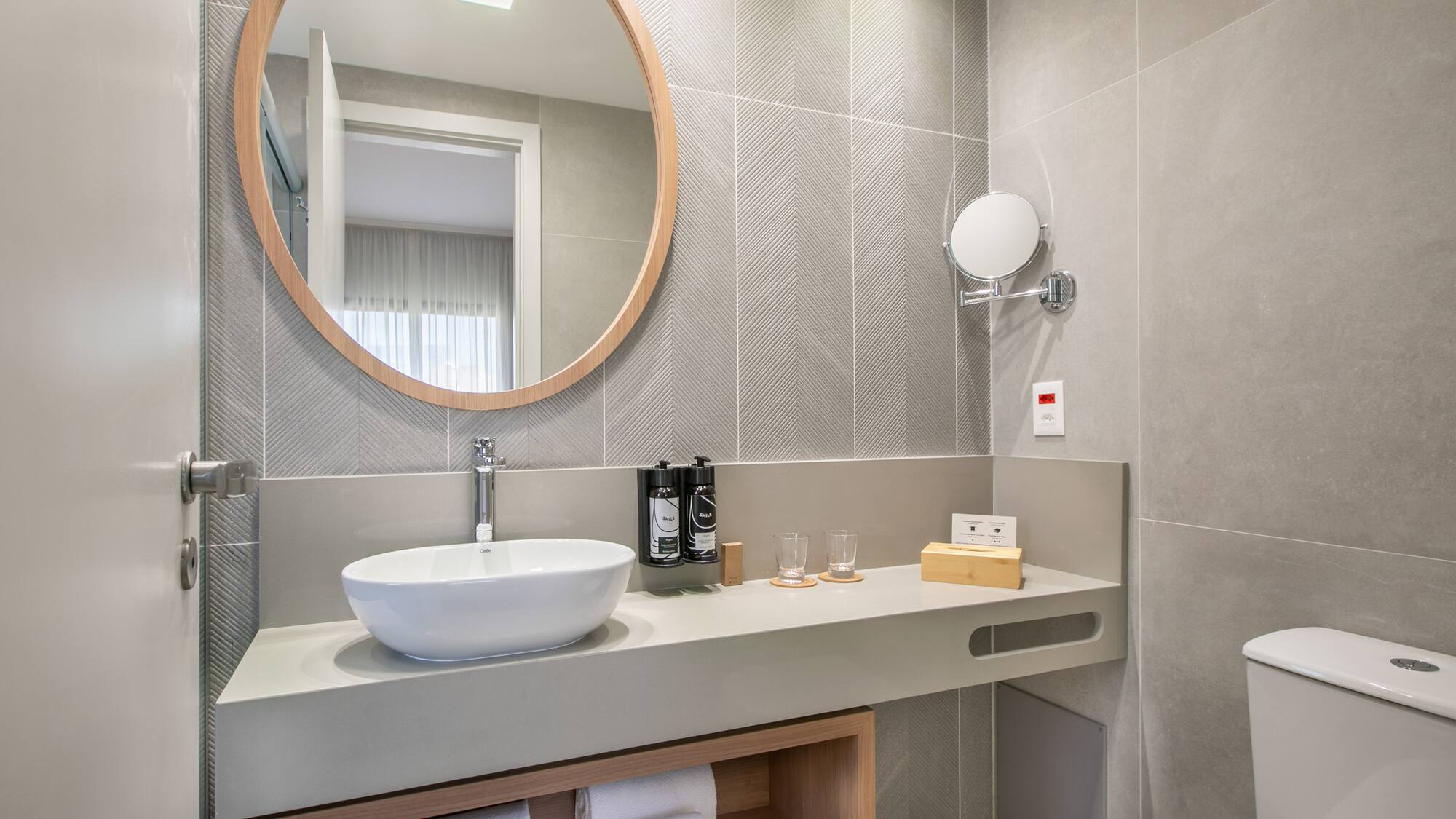 a bathroom with a round mirror and a sink