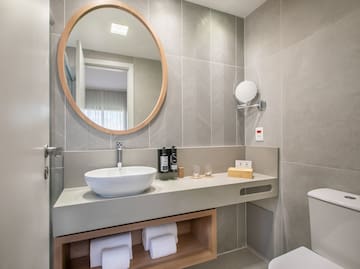 a bathroom with a round mirror and a sink