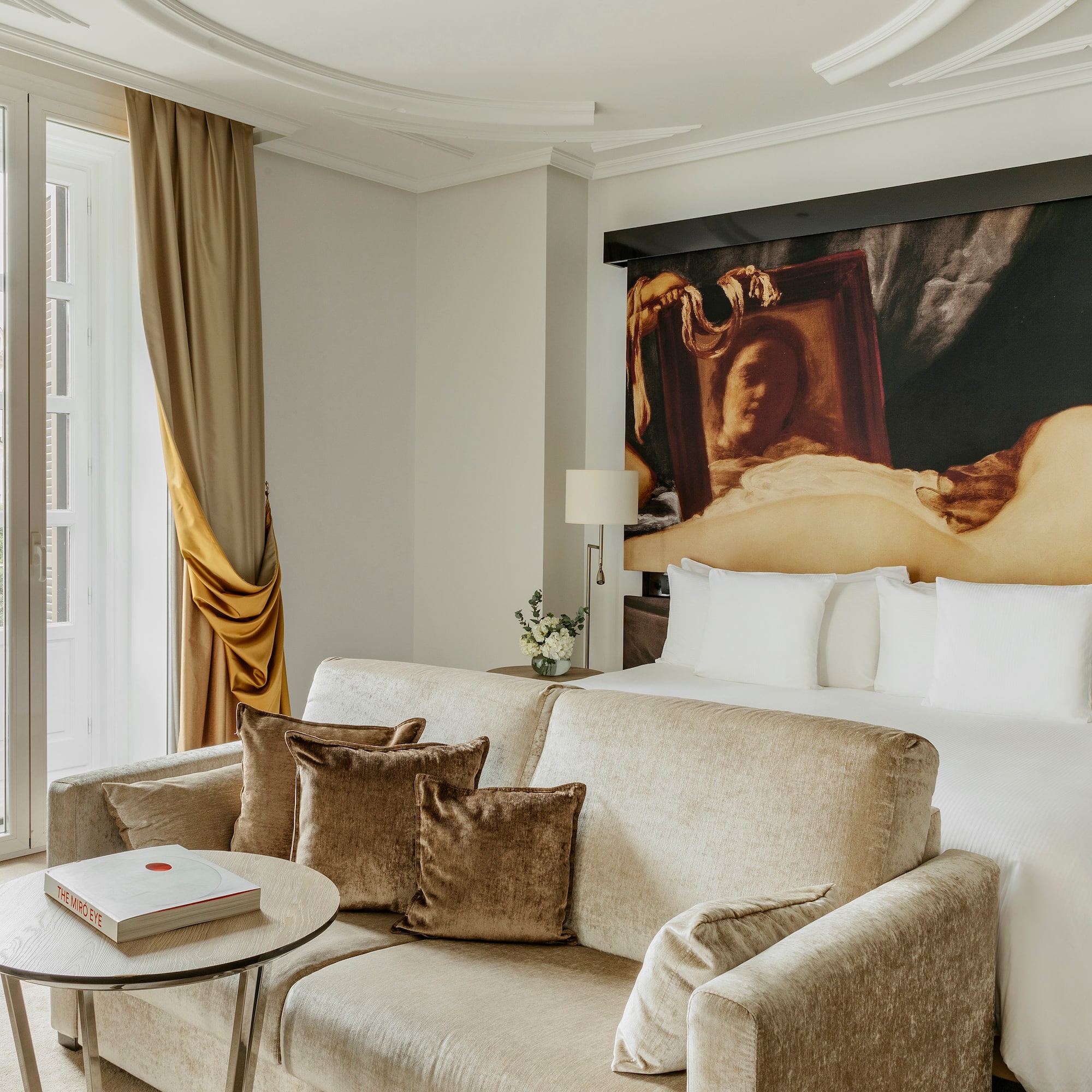 a room with a couch and a painting on the wall