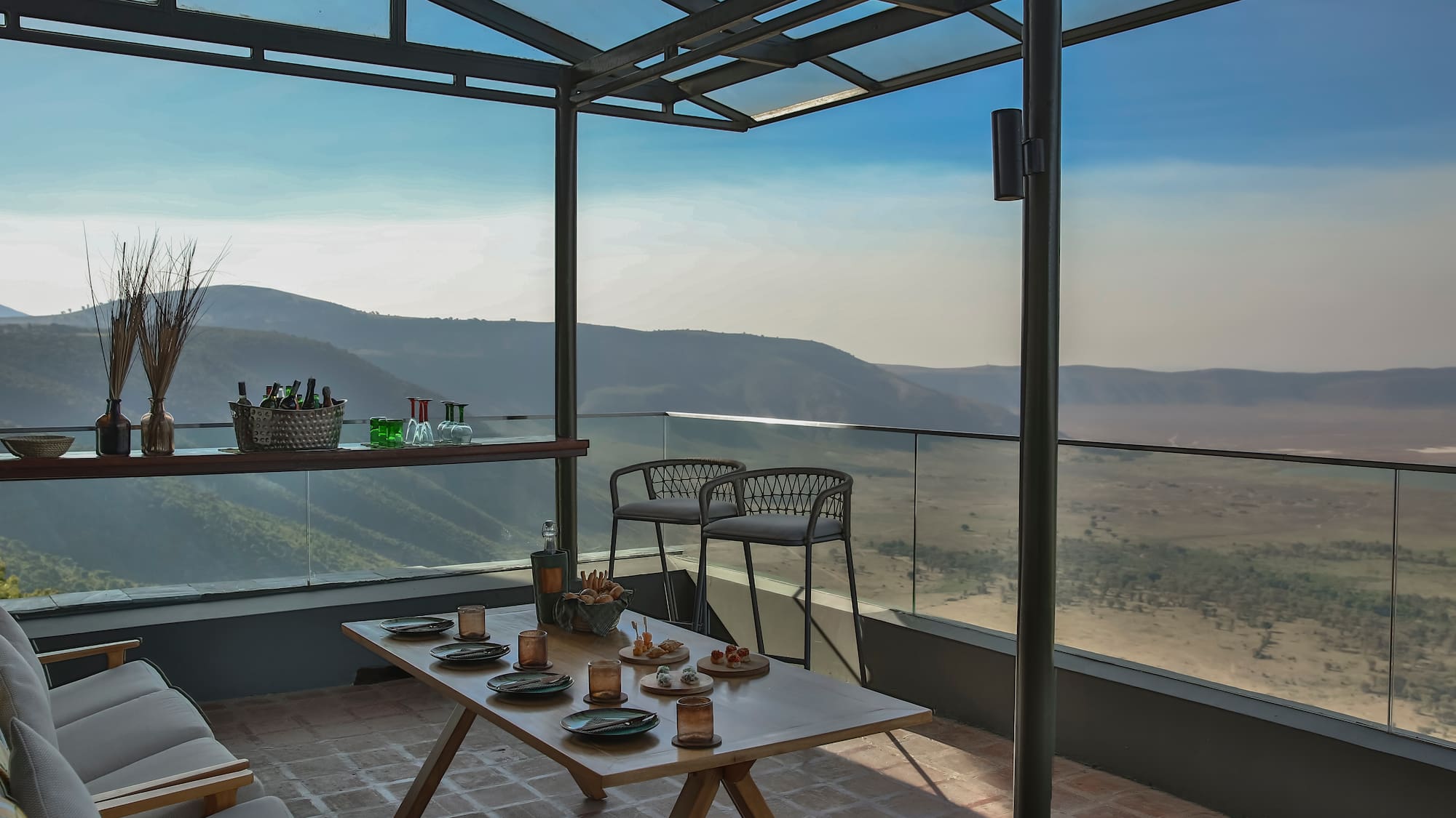 a table with food on it and chairs on a patio with a view of the valley