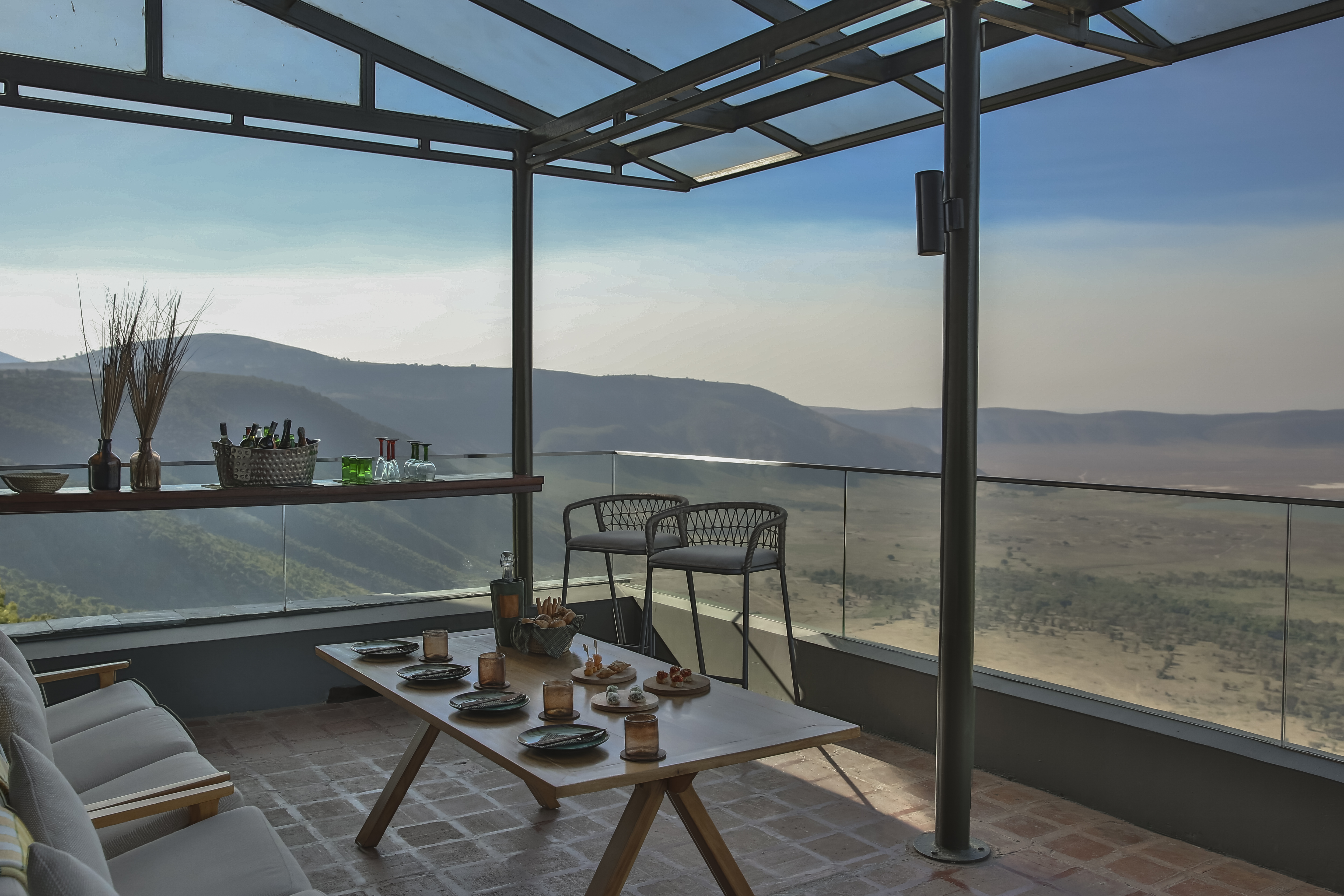 a table with food on it and chairs on a patio with a view of the valley