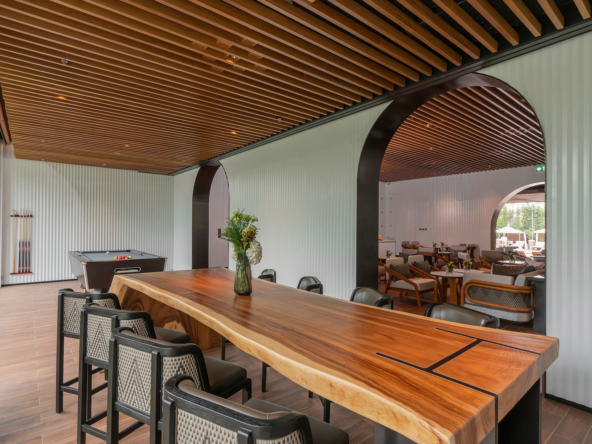 a room with a pool table and chairs