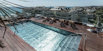 a pool with chairs and a deck overlooking a city