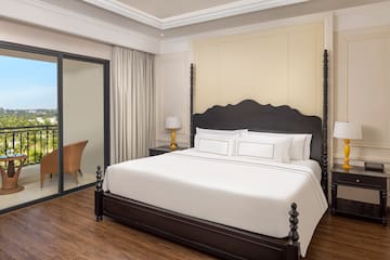 a bed with white sheets and a black headboard