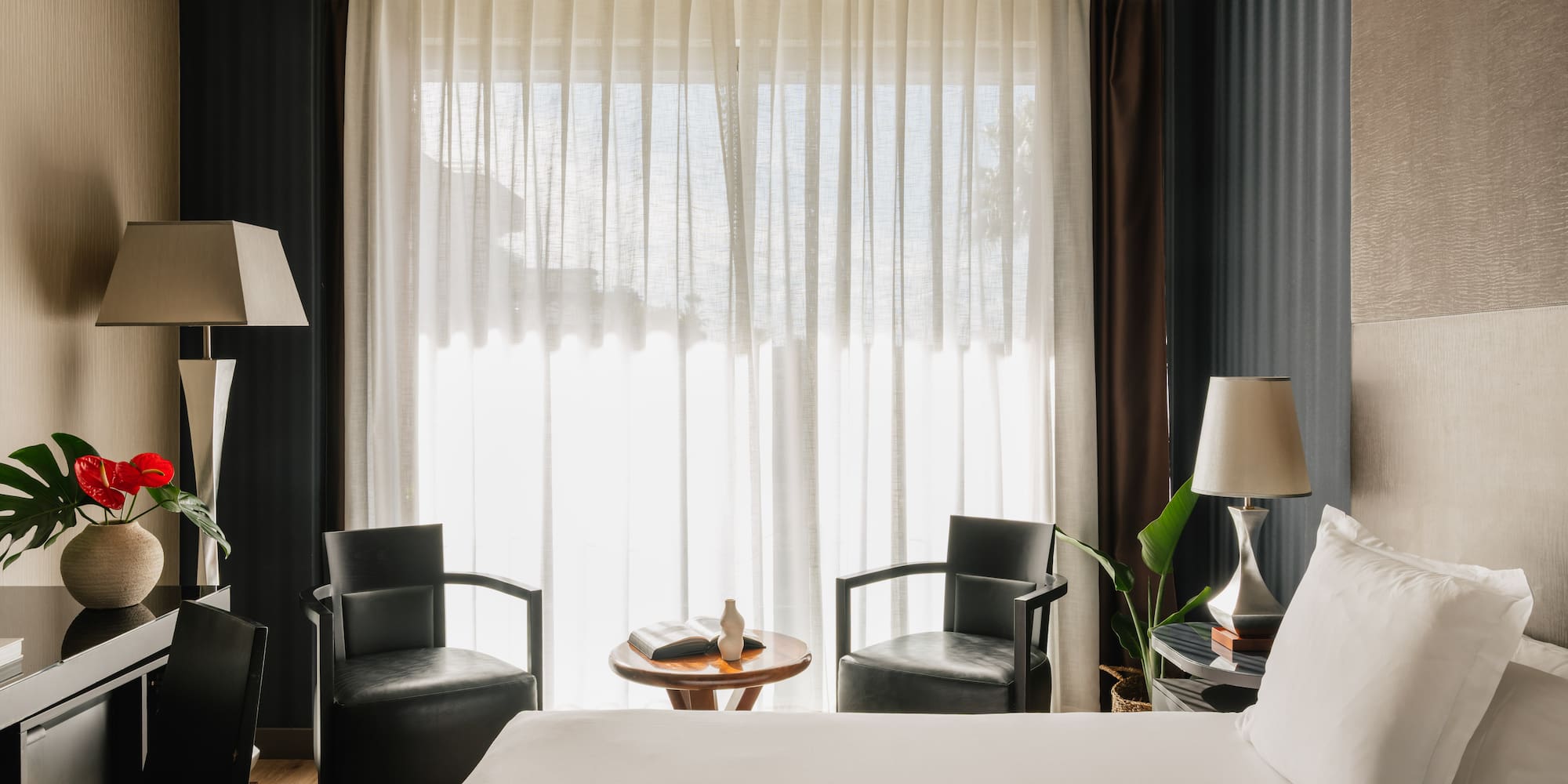 a room with a bed and chairs