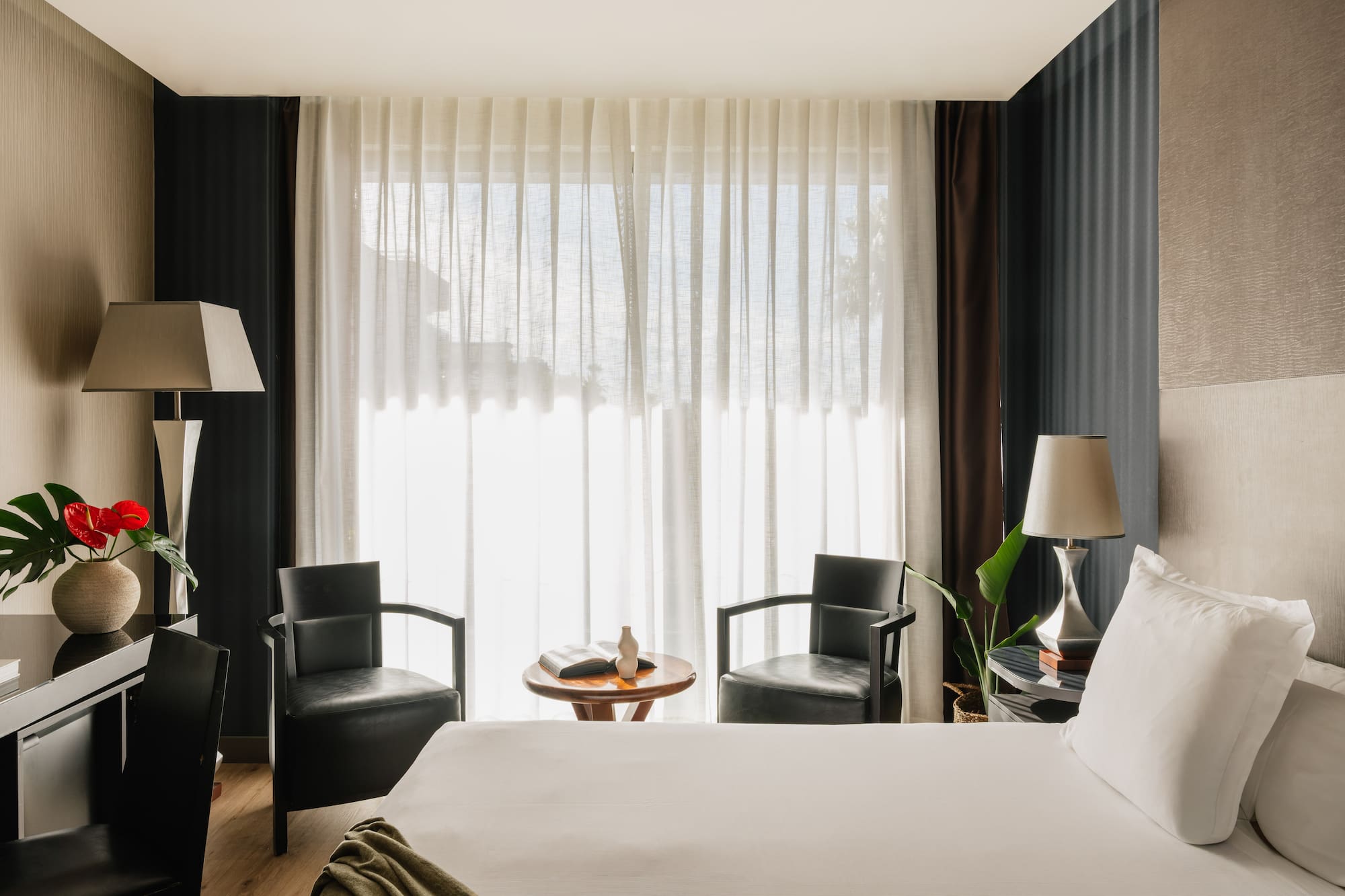 a room with a bed and chairs