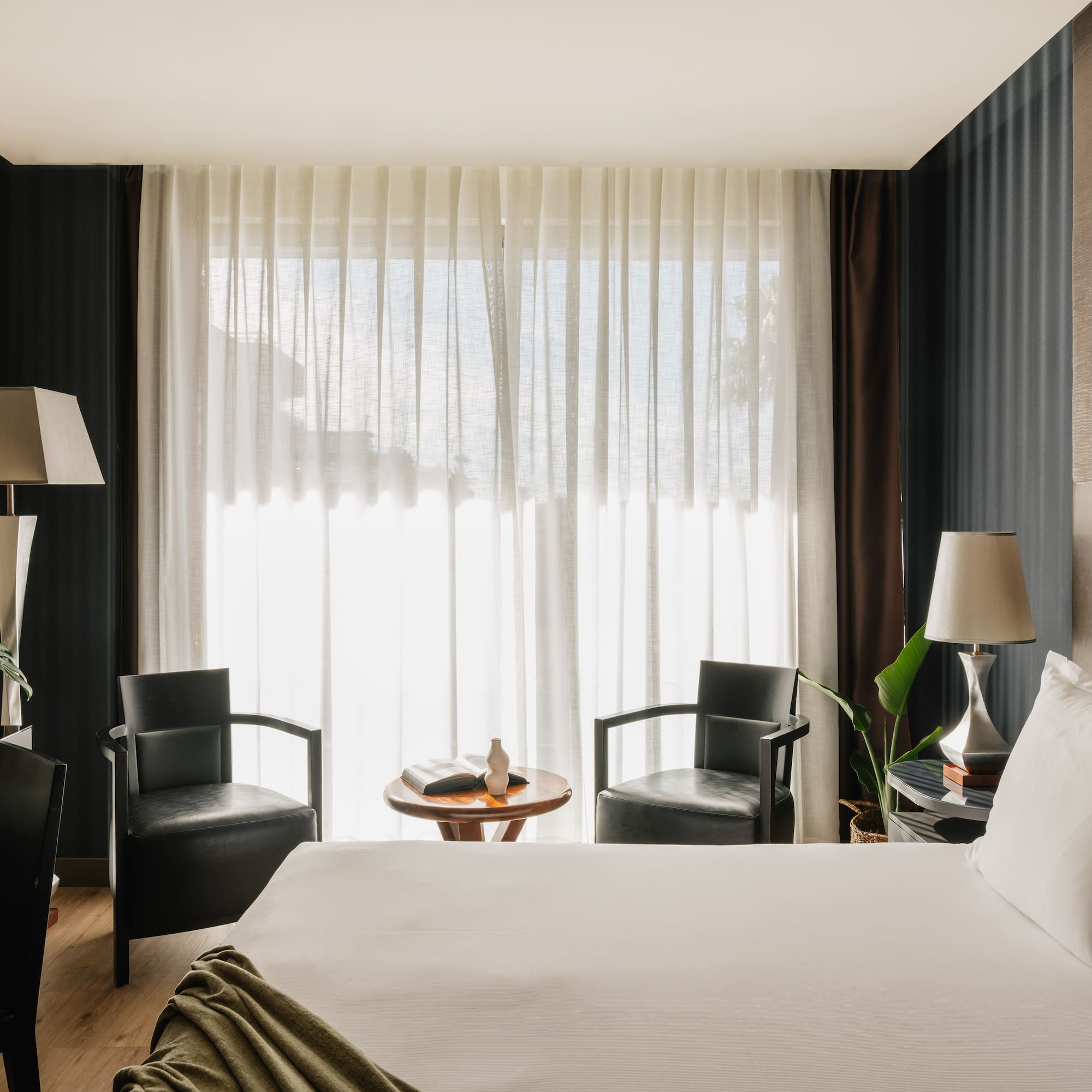 a room with a bed and chairs