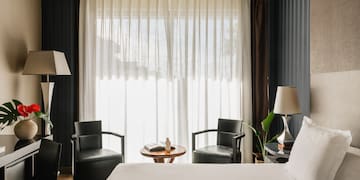 a room with a bed and chairs