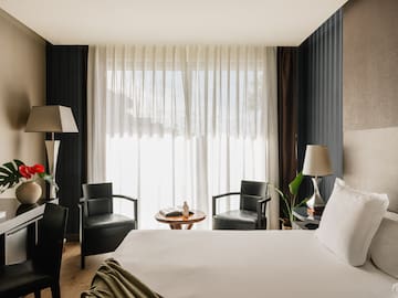 a room with a bed and chairs