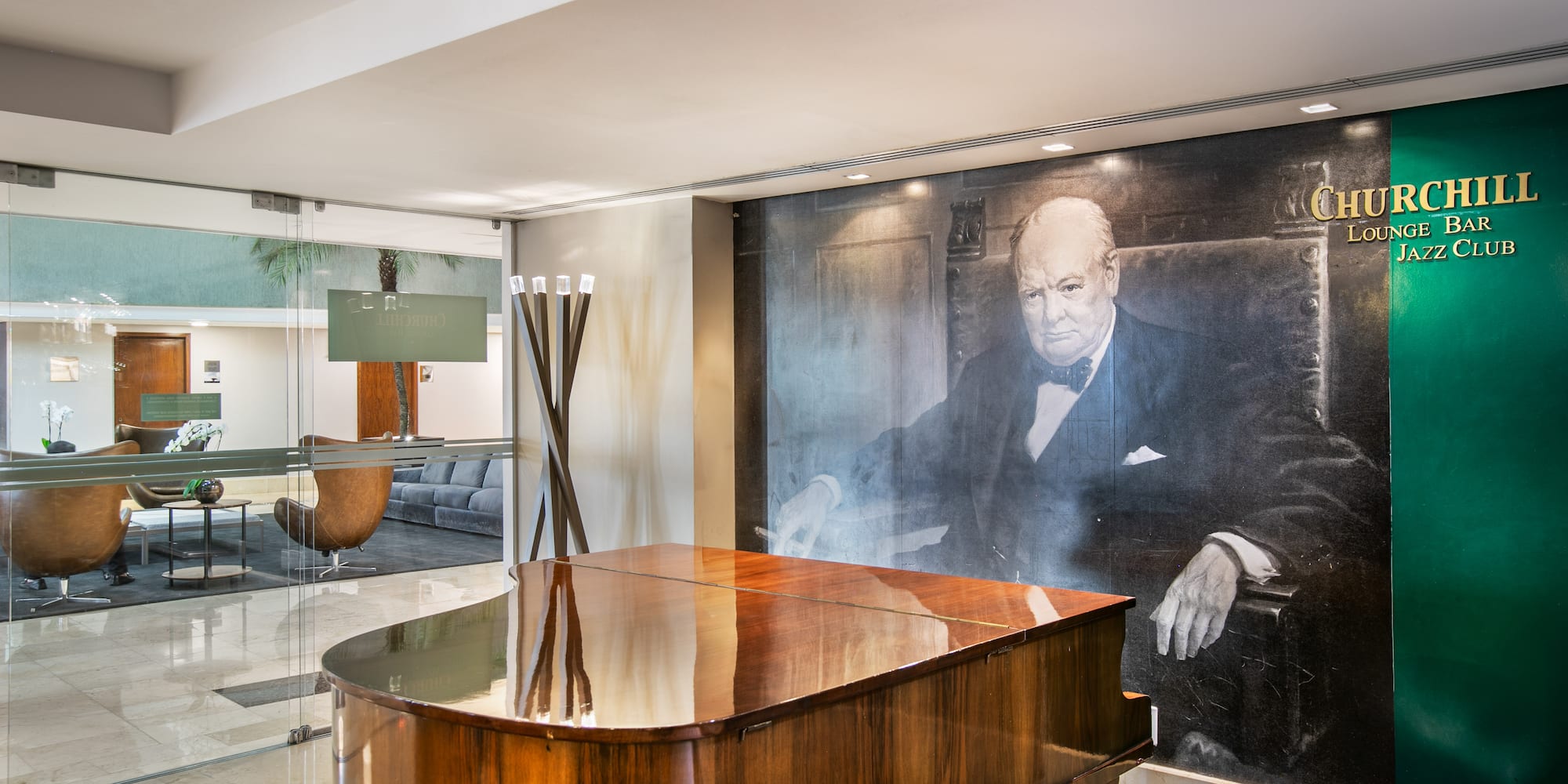 Grand piano and Winston Churchill mural in Churchill Lounge Bar Jazz Club.