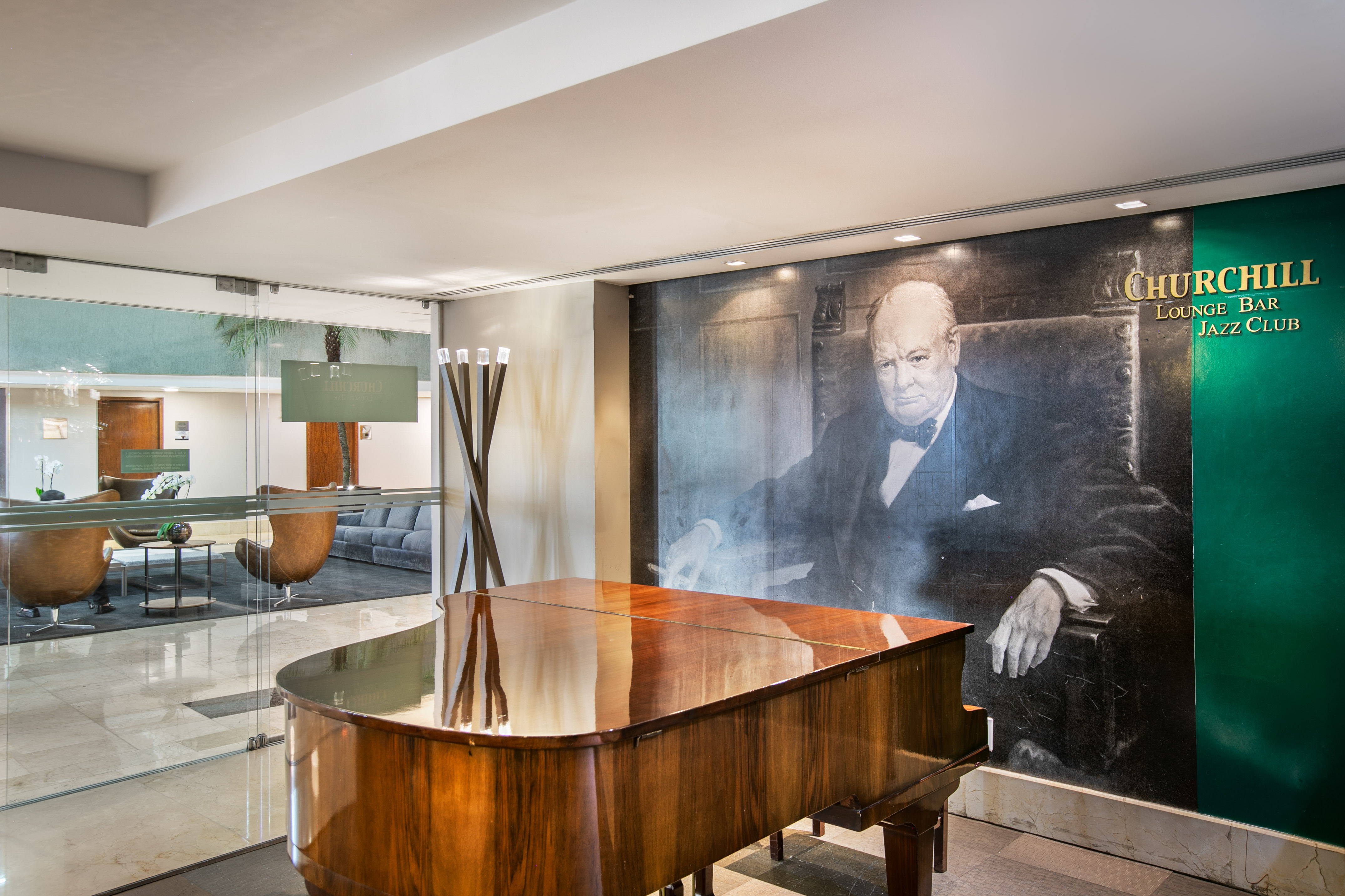 Grand piano and Winston Churchill mural in Churchill Lounge Bar Jazz Club.
