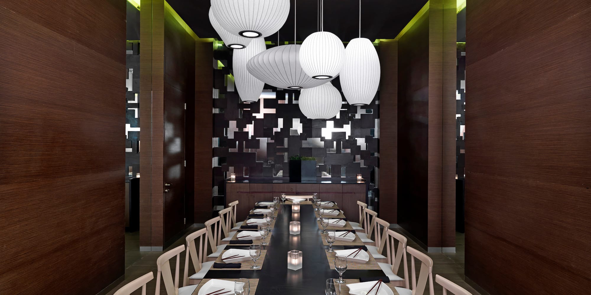 a long table with chairs and plates in a room
