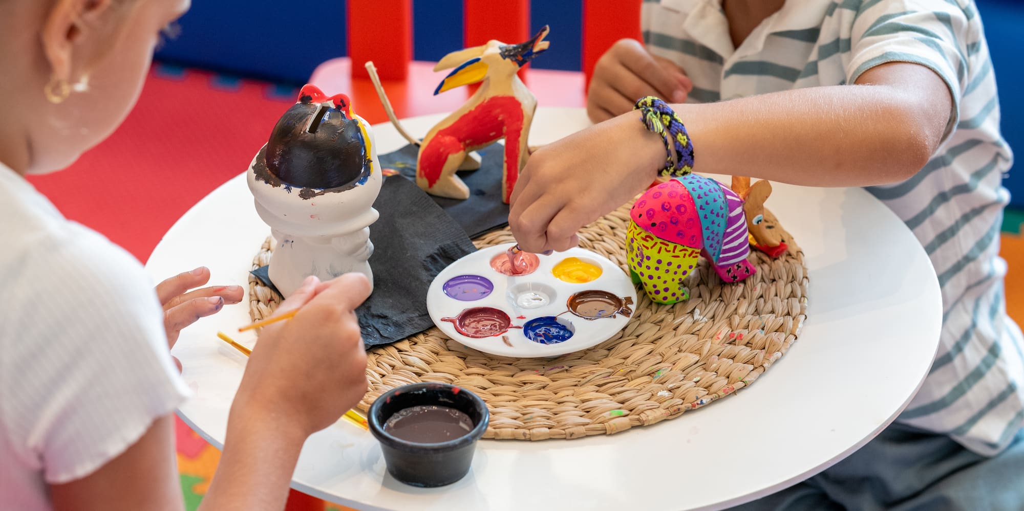 a boy and girl painting on a table