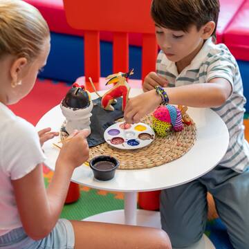 a boy and girl painting on a table