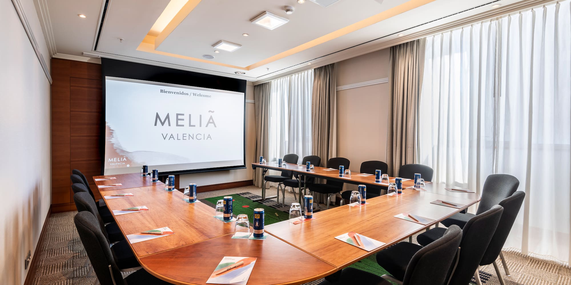 a room with a large screen and tables