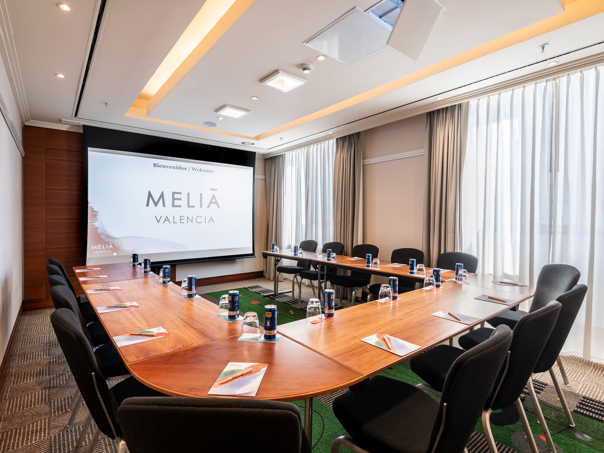 a room with a large screen and tables