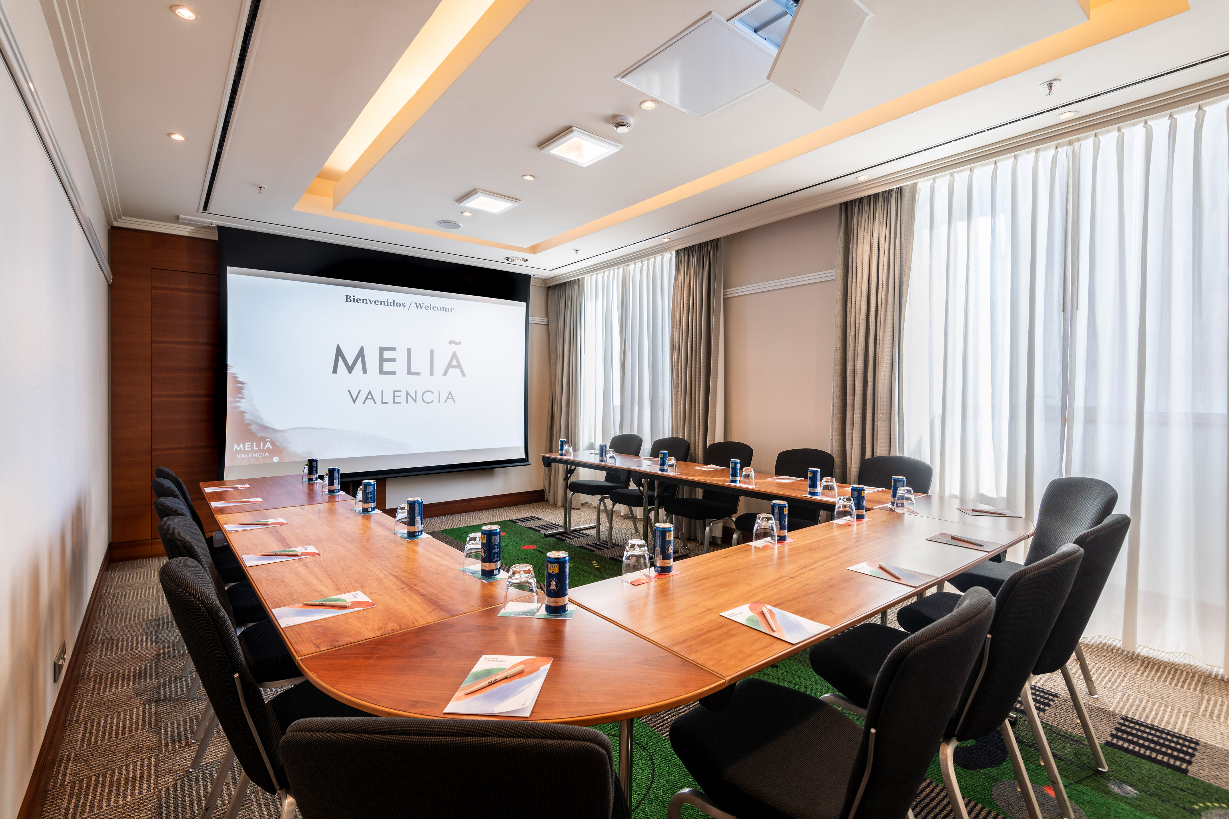 a room with a large screen and tables