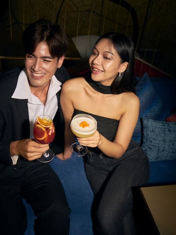 a man and woman holding drinks