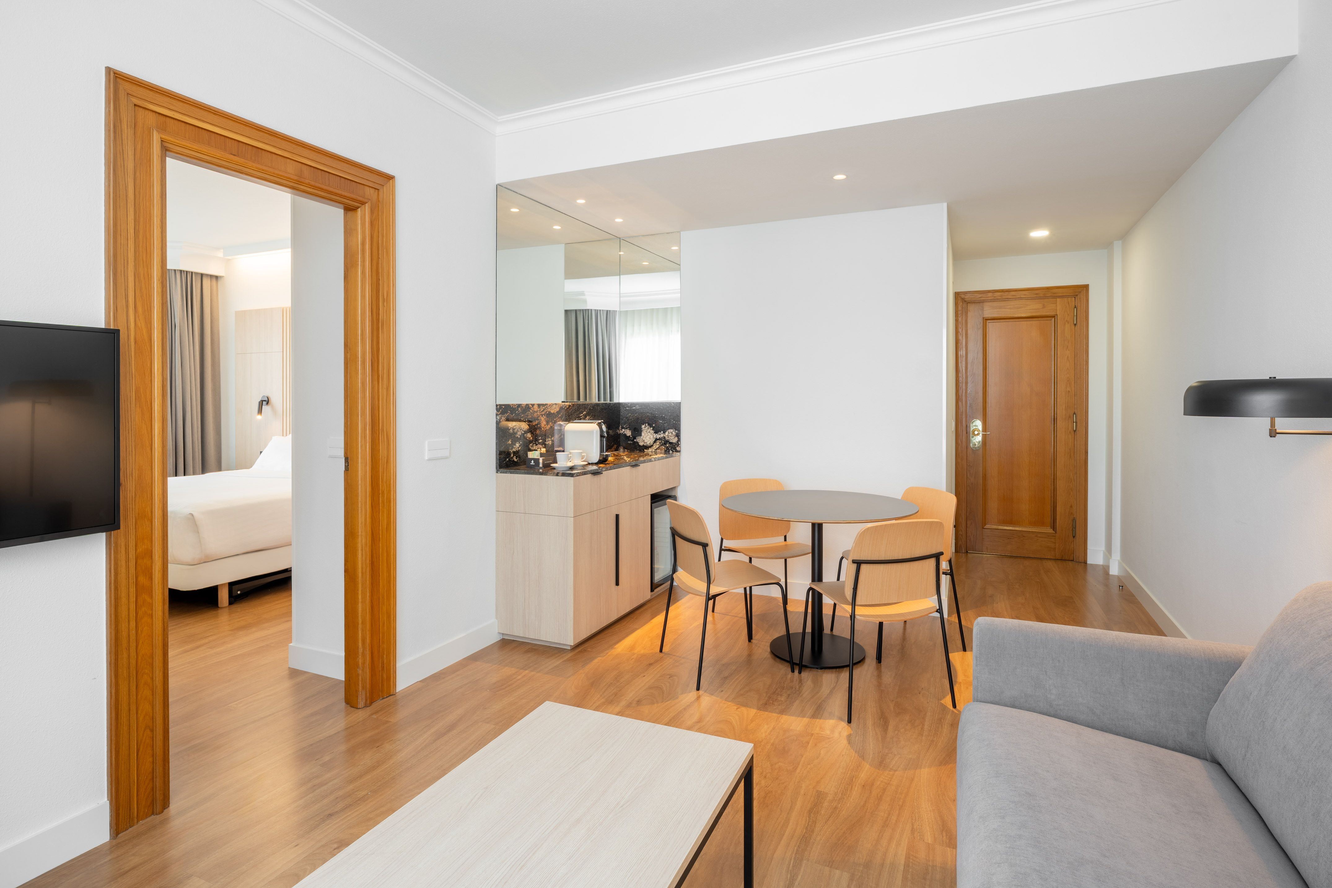 Modern hotel suite: living room, kitchenette, dining area, bedroom.