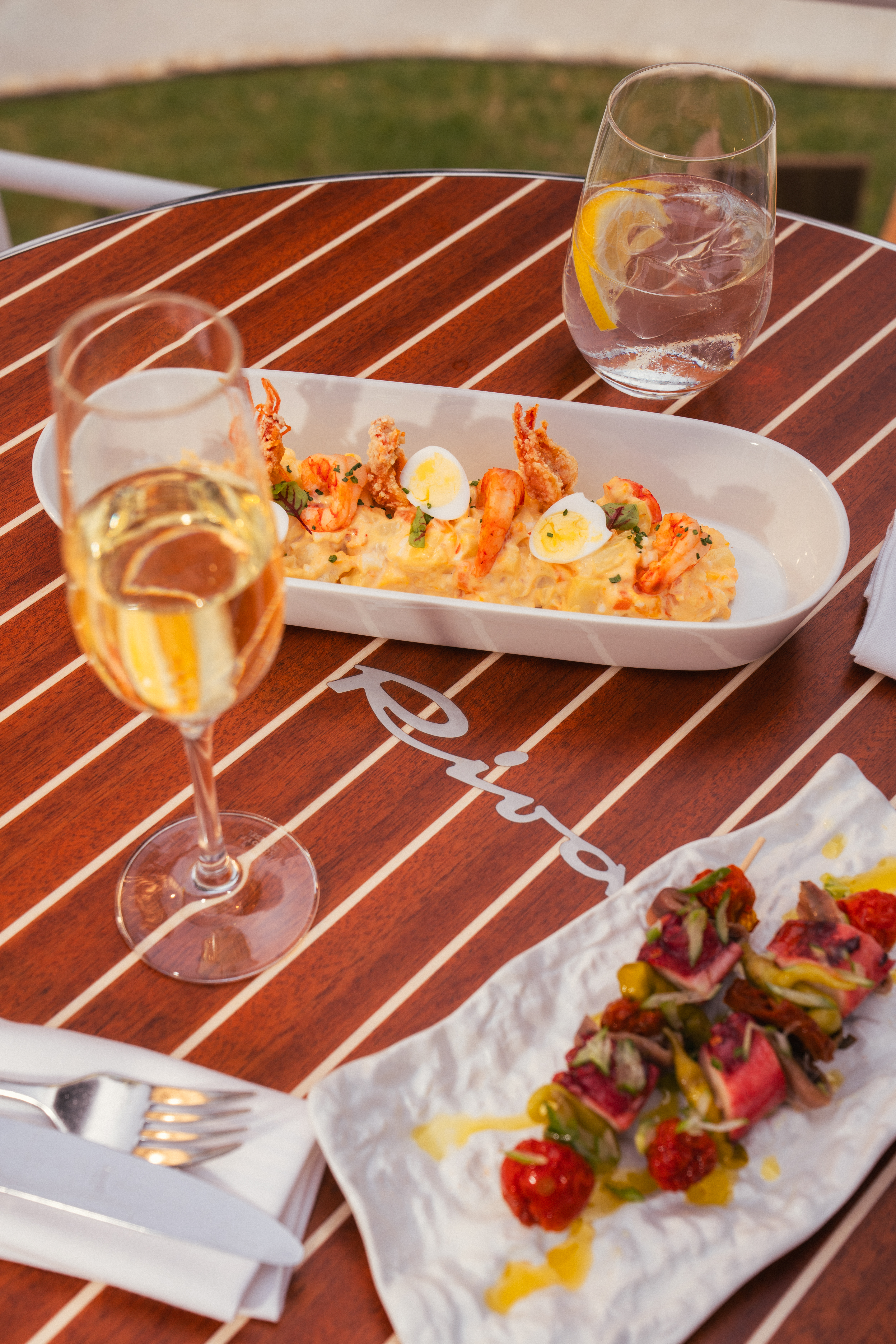 Shrimp potato salad, seafood skewers, champagne on a luxury Riva deck.