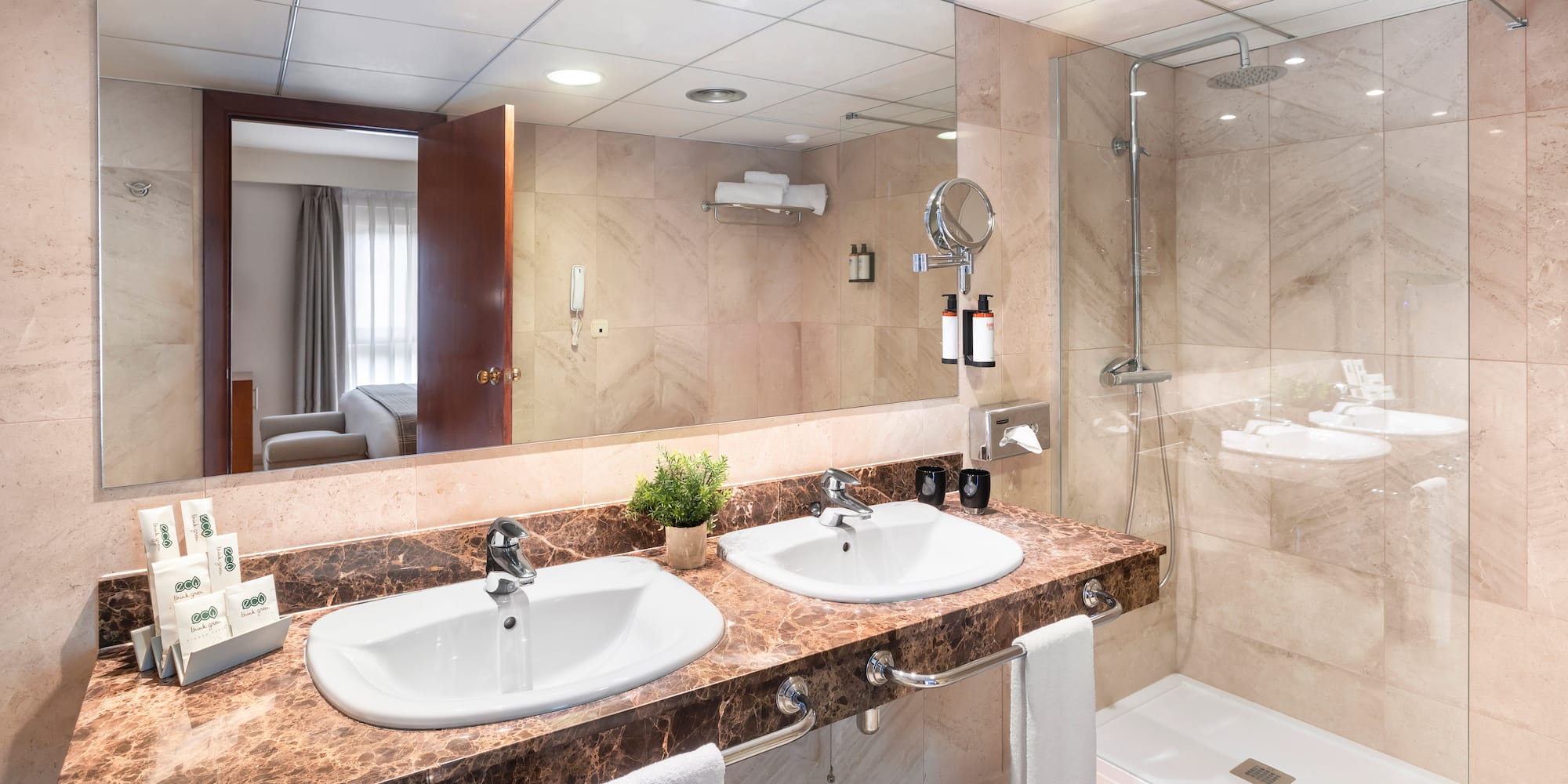 a bathroom with marble countertop sinks and shower