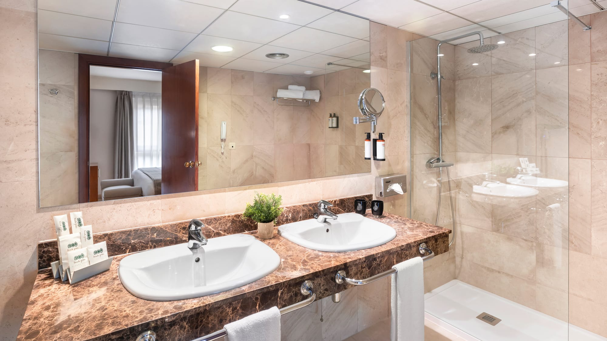 a bathroom with marble countertop sinks and shower