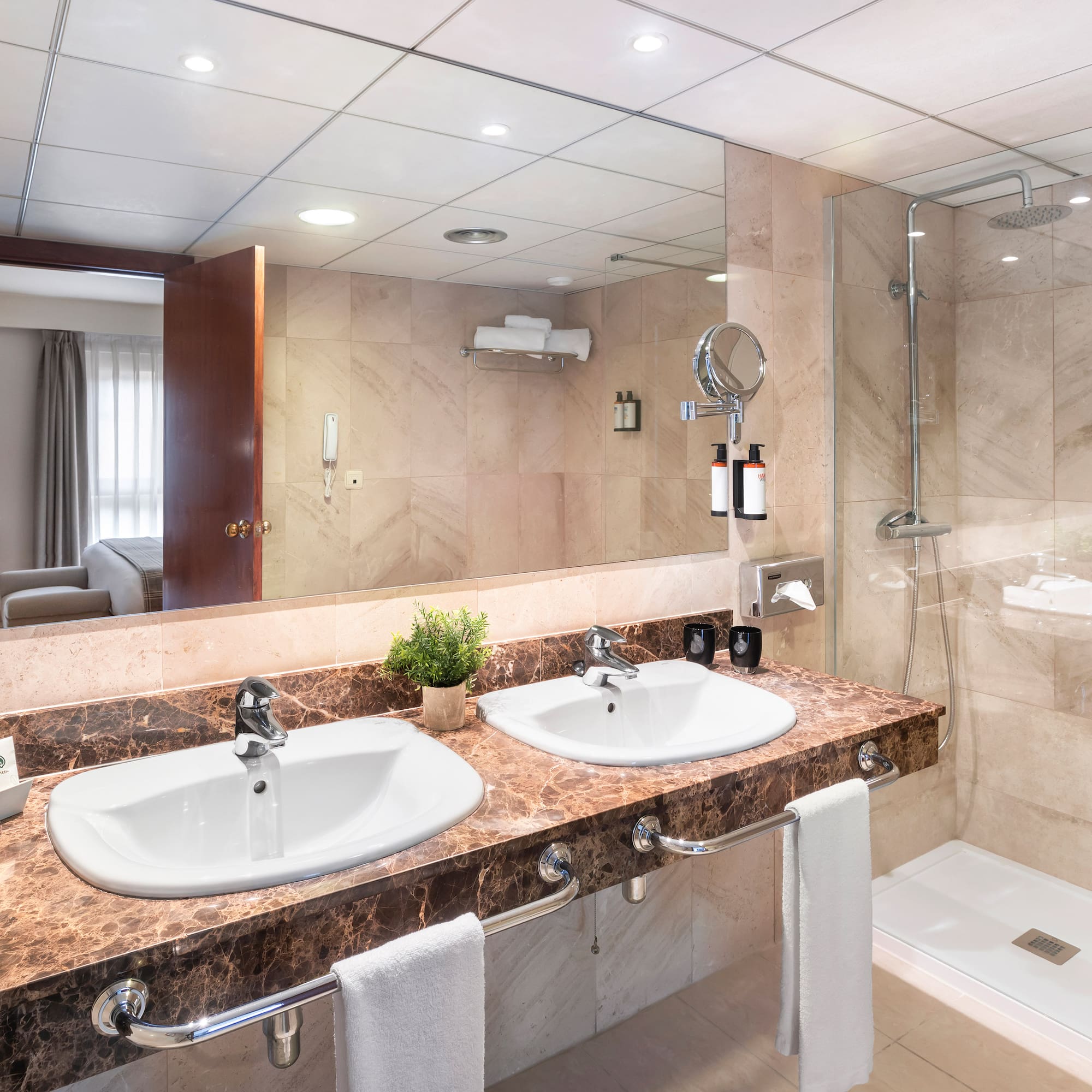 a bathroom with marble countertop sinks and shower