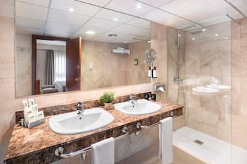a bathroom with marble countertop sinks and shower