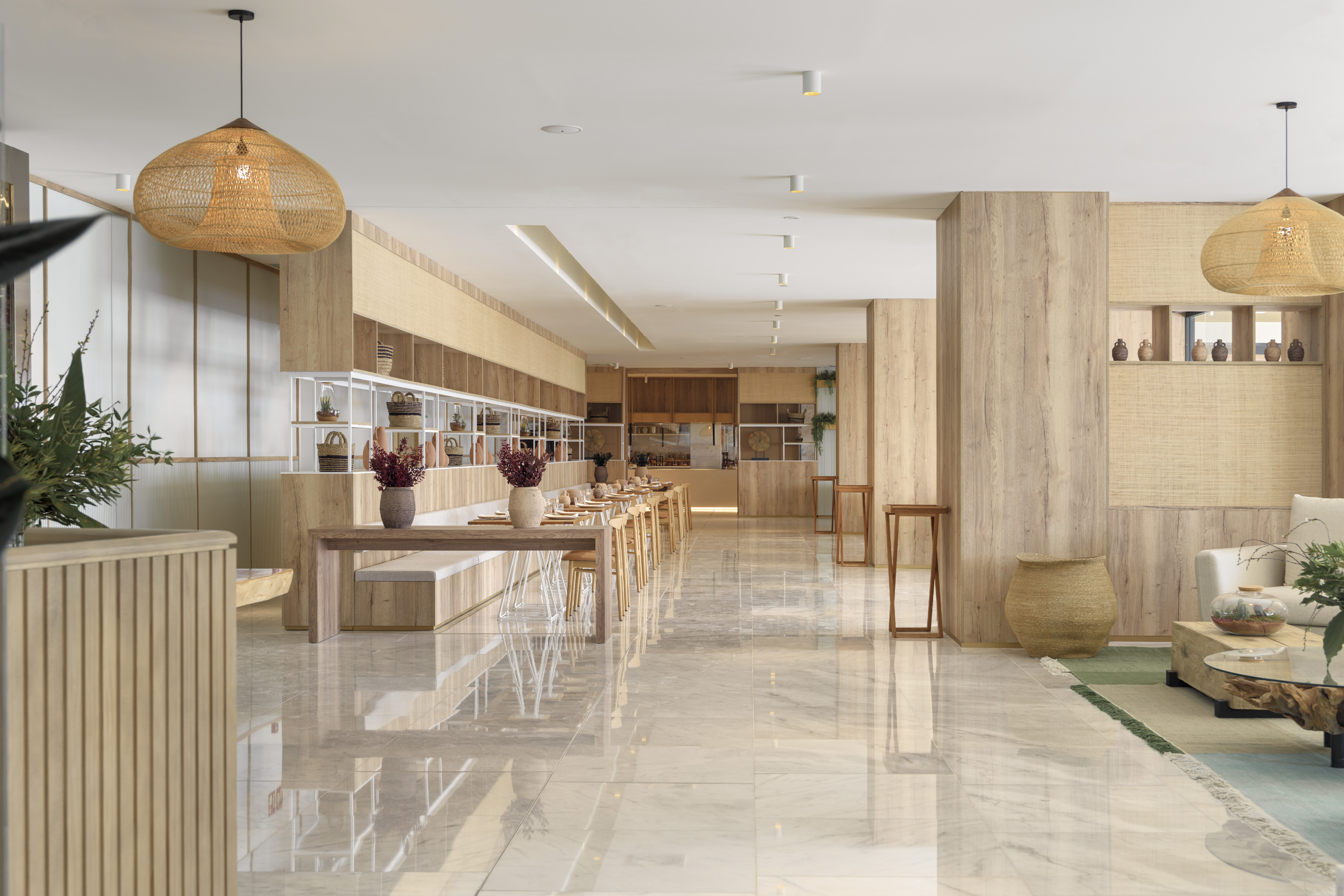 Modern dining hall with wood, woven lights, and reflective marble floor.