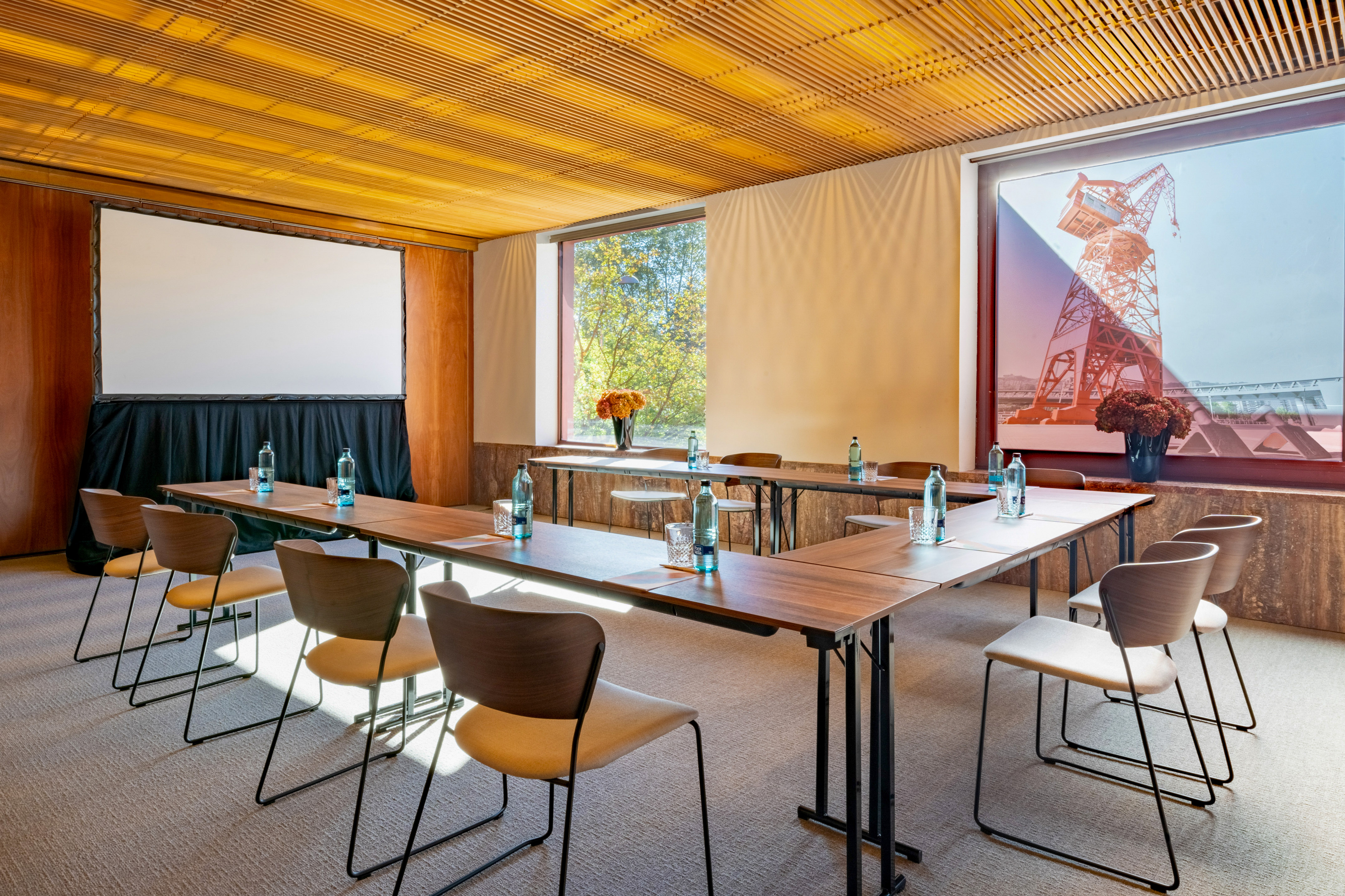 Modern U-shape conference room with projector screen and wood slat ceiling.