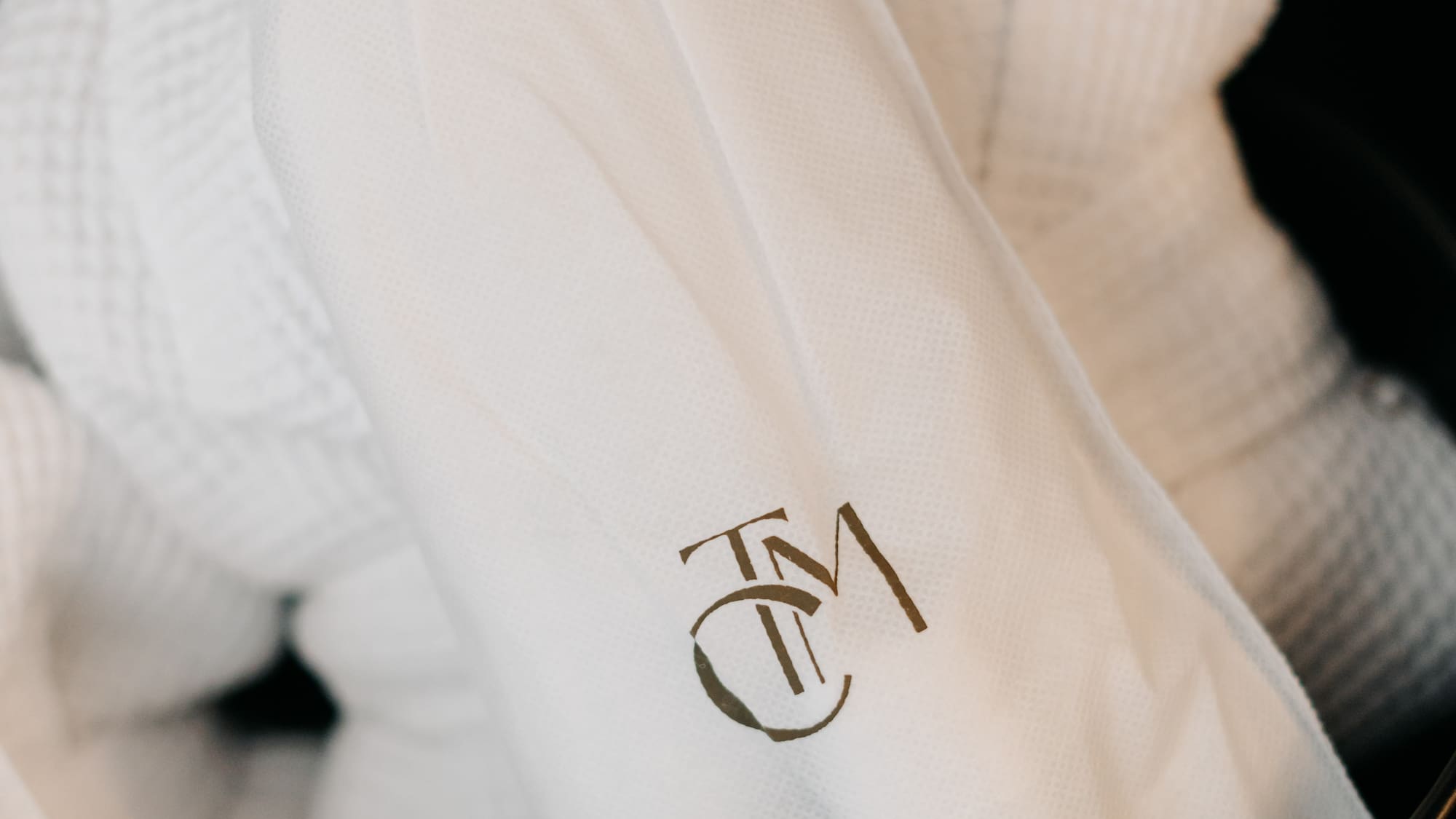 a white bathrobe with a logo on it