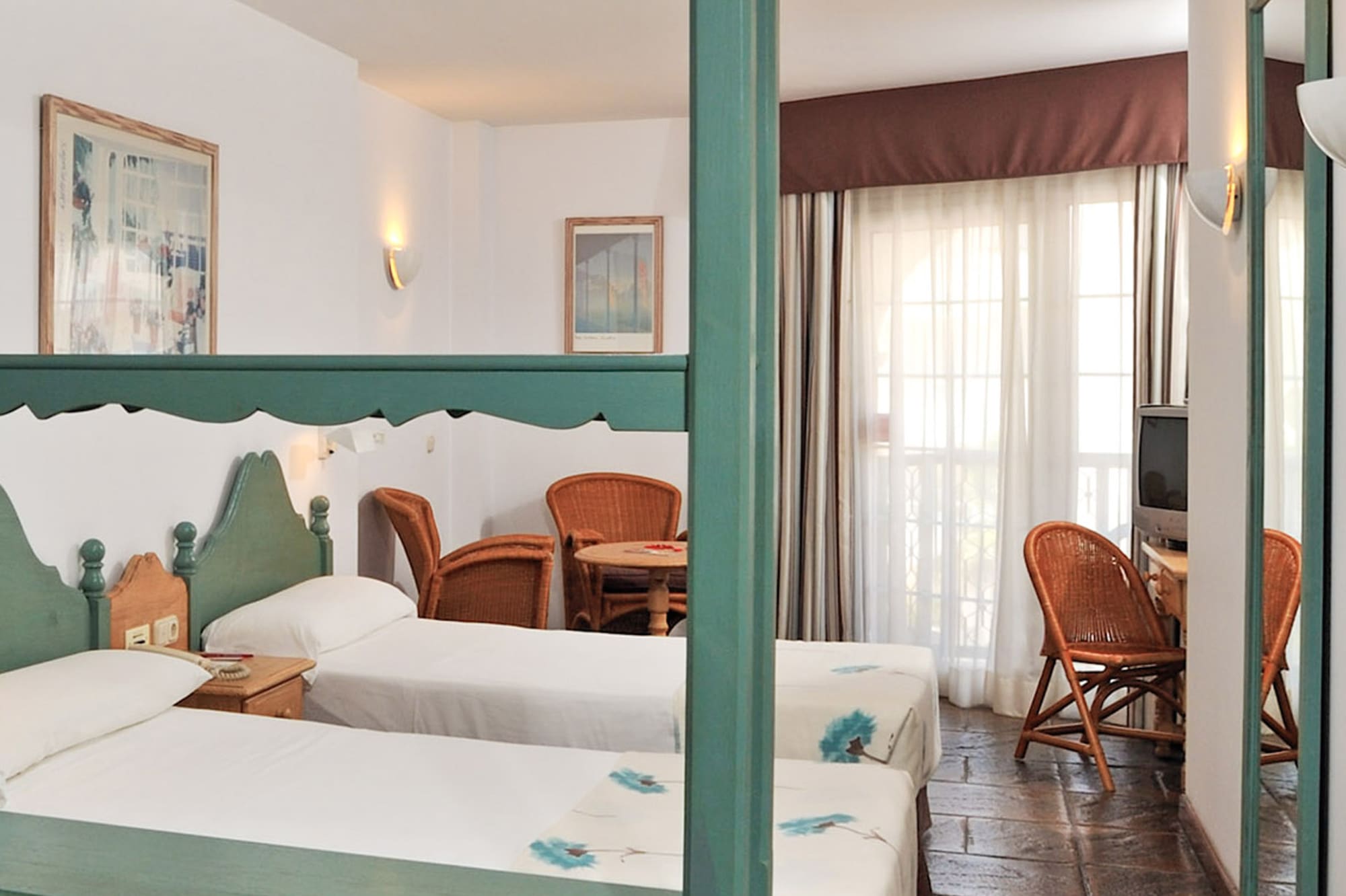 a room with two beds and a television