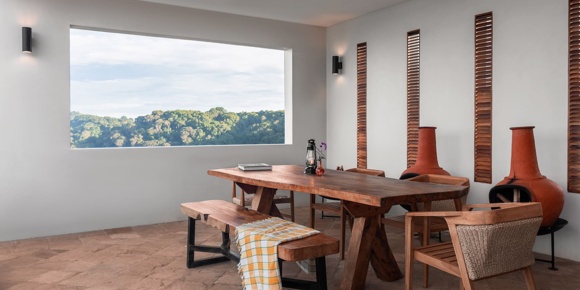 a table and chairs in a room with a view of trees