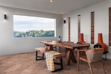 a table and chairs in a room with a view of trees