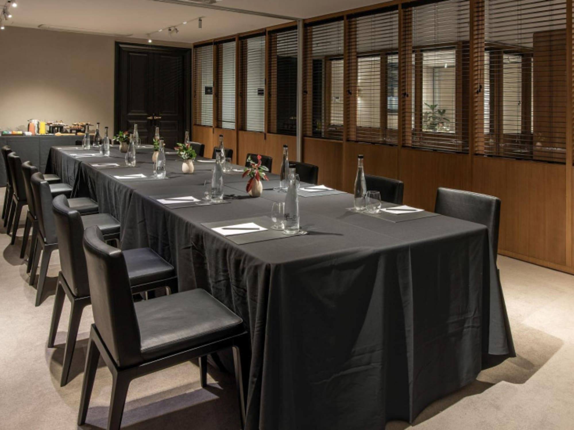 a long table with black tablecloth and chairs