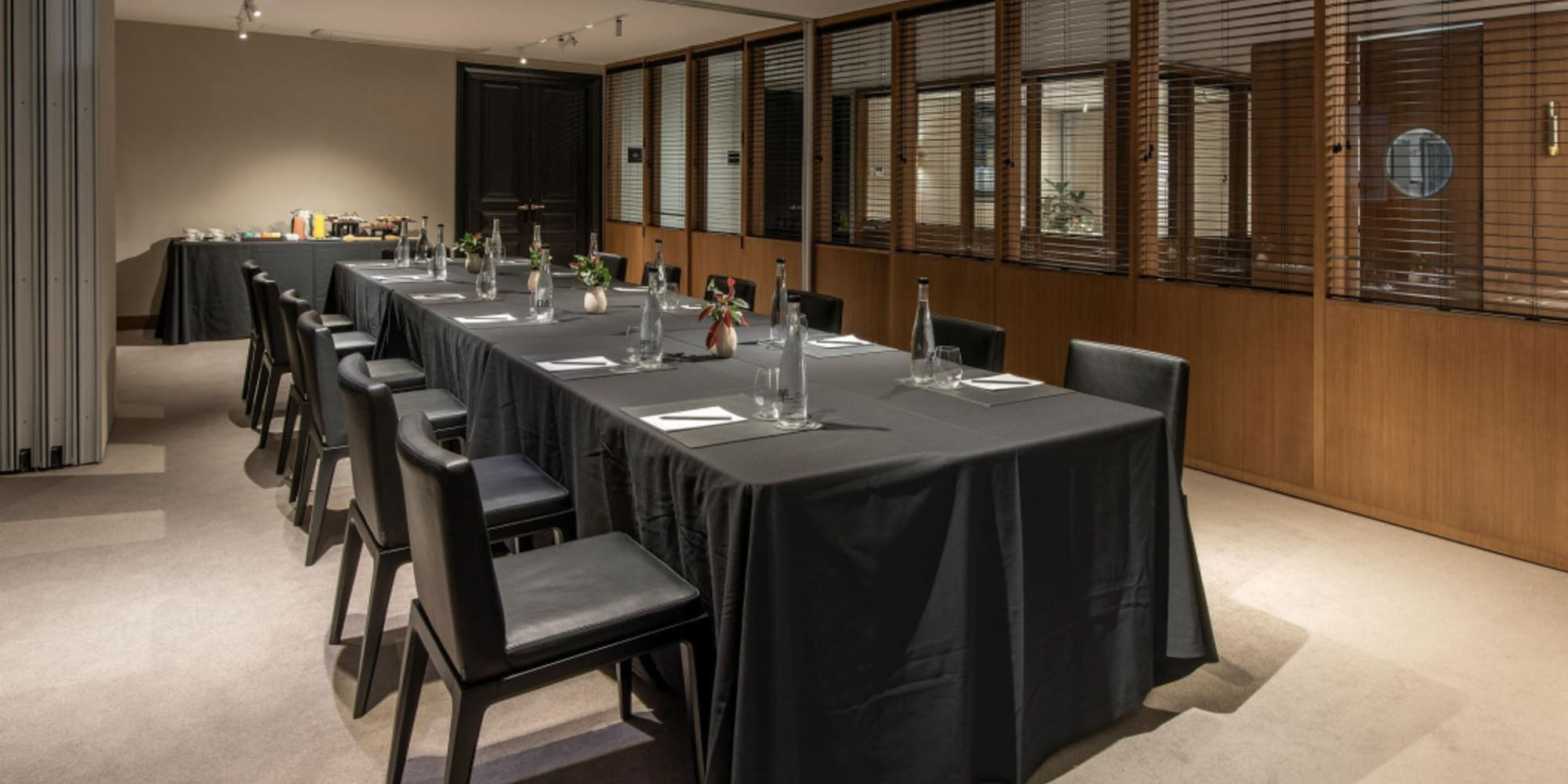 a long table with black tablecloth and chairs