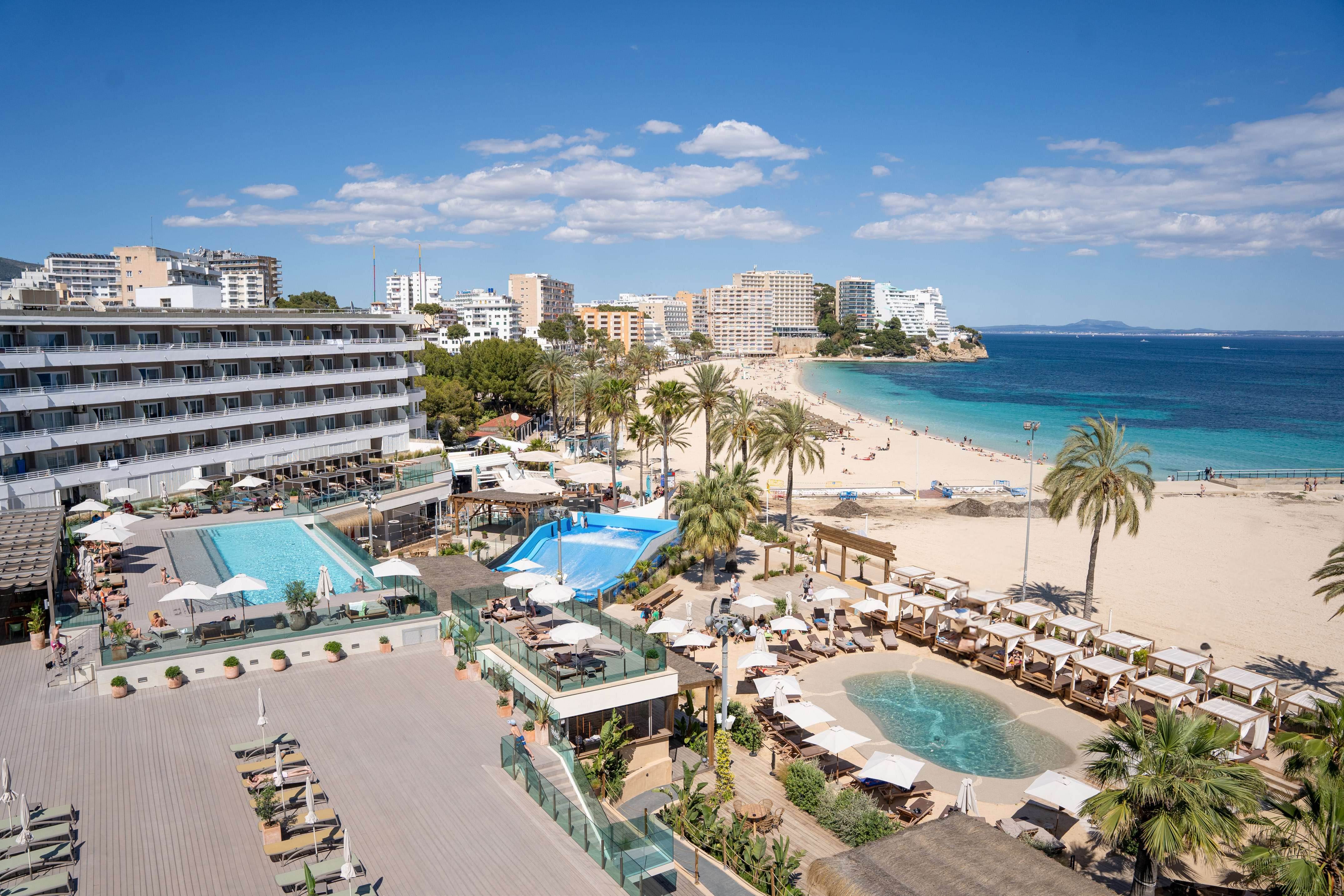Coastal town skyline with hotels and apartments by the blue Mediterranean sea.